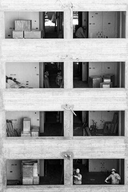 Workers at a multi-story building site in Buenos Aires, captured in monochrome.